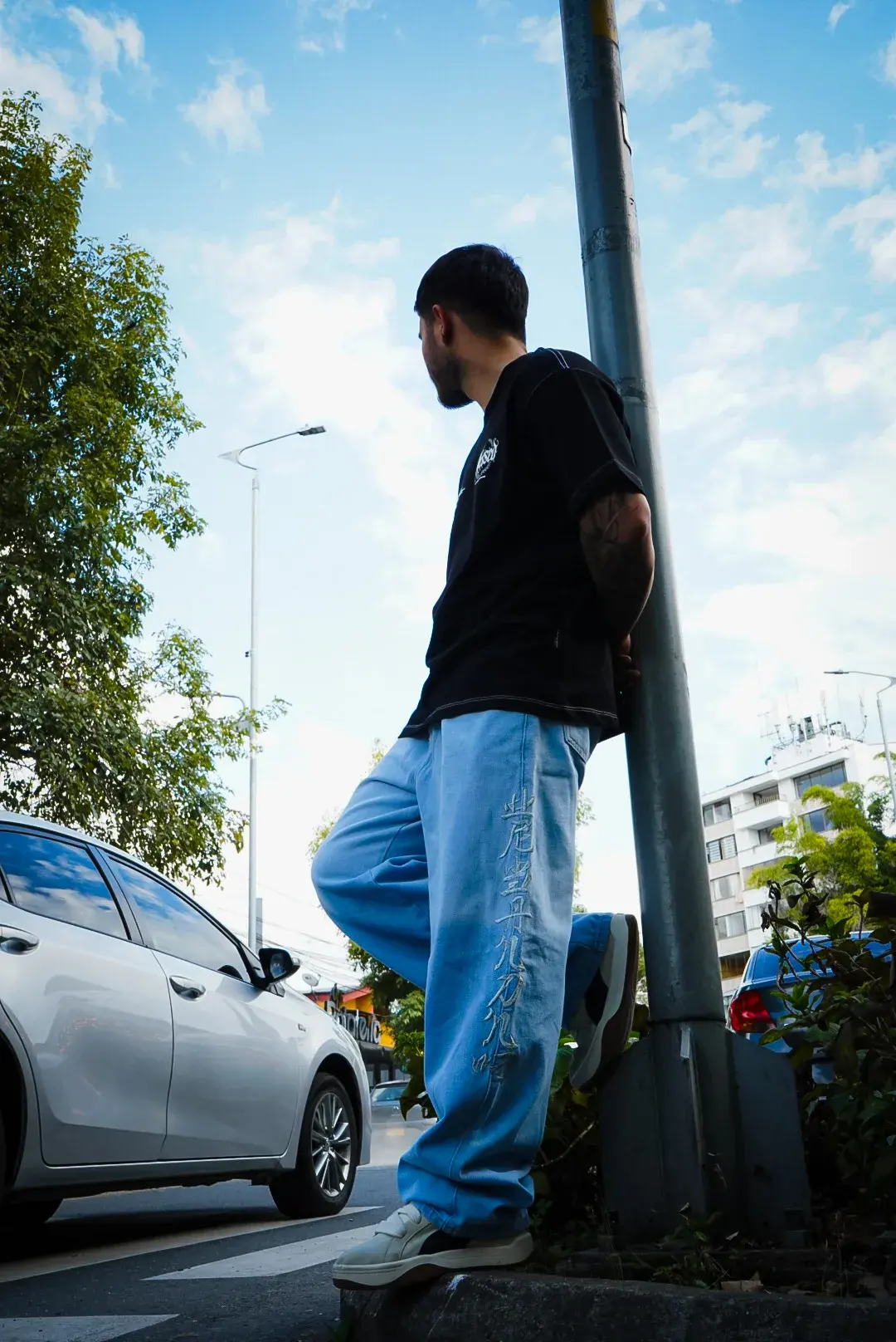Modelo apoyado en un poste con el Baggy Letras Chinas